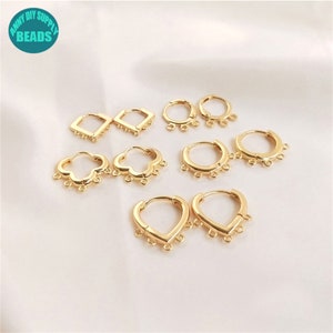 Puede incluir: Un conjunto de aros de pendientes de color dorado con diferentes formas, incluyendo formas cuadradas, redondas y de corazón. Cada aro tiene múltiples bucles pequeños que cuelgan de la parte inferior.