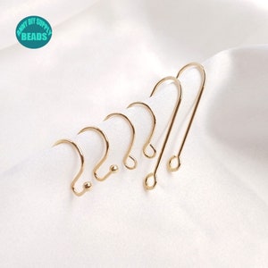 May include: A set of five gold-toned earring hooks, with varying sizes and styles. The hooks are arranged in a row, with the largest hook on the right and the smallest hook on the left.