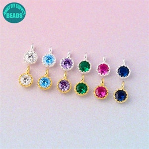 Puede incluir: Surtido de 10 pequeños abalorios redondos de tono dorado con un solo strass en el centro. Los strass son de varios colores, incluyendo transparente, azul, verde, morado y rojo.