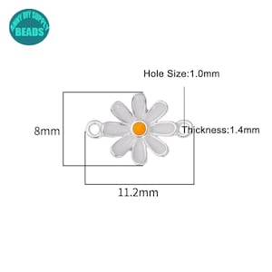 K&ouml;nnte beinhalten: Wei&szlig;er, margeritenf&ouml;rmiger Anh&auml;nger mit orangefarbenem Zentrum und silberfarbenen R&auml;ndern. Der Anh&auml;nger ist 11,2 mm lang, 8 mm breit und 1,4 mm dick, mit einem Loch von 1,0 mm. Der Anh&auml;nger ist f&uuml;r DIY-Zubeh&ouml;r-Perlen.