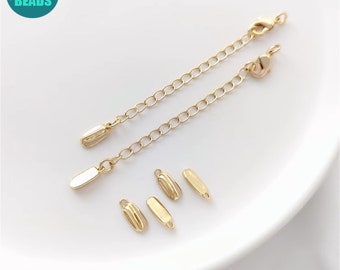 May include: Gold-colored jewelry extenders and clasps. Two chain extenders with lobster claw clasps are shown, along with four small, gold-toned oval connector pieces. The items are displayed on a white surface.