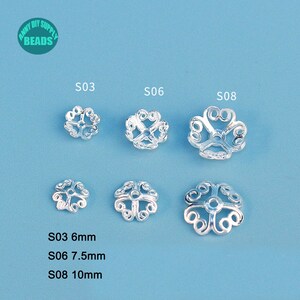 May include: Silver-colored metal bead caps in various sizes, arranged on a light blue surface. The caps have an openwork, floral design. The image includes text indicating sizes: S03 (6mm), S06 (7.5mm), and S08 (10mm). The top left corner has a logo.