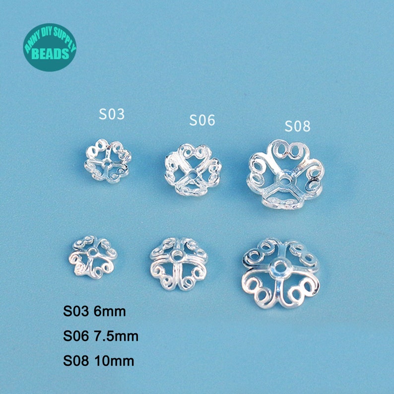 May include: Silver-colored metal bead caps in various sizes, arranged on a light blue surface. The caps have an openwork, floral design. The image includes text indicating sizes: S03 (6mm), S06 (7.5mm), and S08 (10mm). The top left corner has a logo.