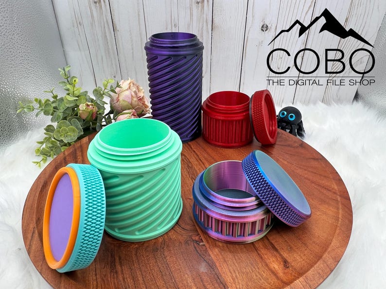 Op de afbeelding: Een verzameling kleurrijke, 3D-geprinte containers met een textuuroppervlak en schroefdeksels. De containers zijn in verschillende kleuren, waaronder paars, rood, groen en iriserend. De containers worden op een houten dienblad gepresenteerd.