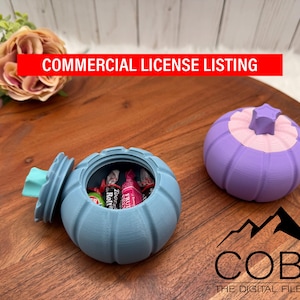 Könnte beinhalten: Zwei kürbisförmige Behälter auf einem Holztablett. Einer ist blau und offen, gefüllt mit Süßigkeiten, der andere ist lila und geschlossen. Der Text "COMMERCIAL LICENSE LISTING" ist im Bild enthalten.