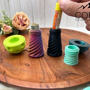May include: A collection of small, screw-top storage containers in various colors including lime green, a rainbow gradient, black, and mint green. One container holds a rolled twenty-dollar bill, and another holds a yellow tube of tropical lip balm.