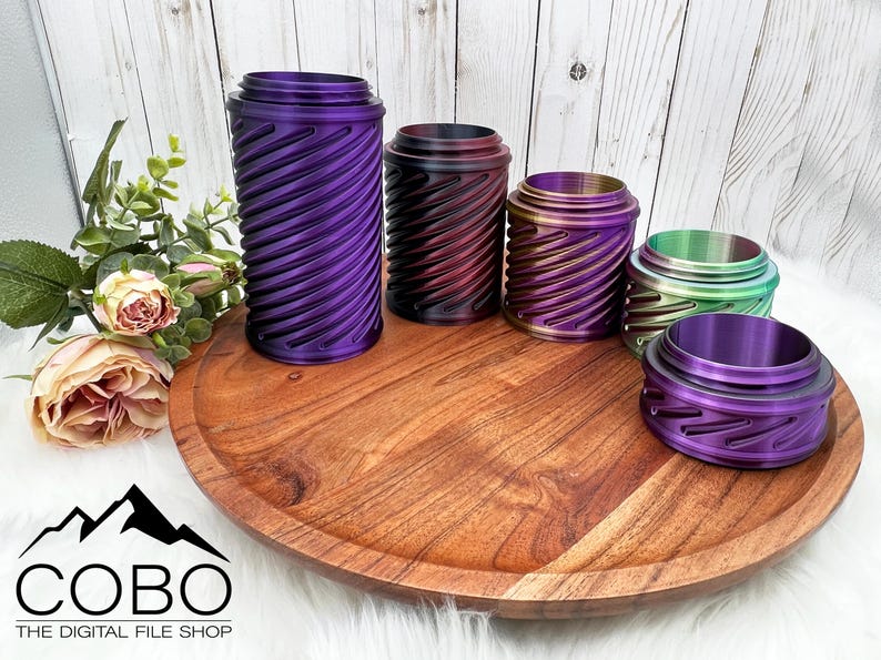 May include: Five iridescent metal containers with a swirling pattern on a wooden tray. The containers are in shades of purple, red, gold, green, and blue.
