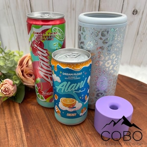 Può includere: Un assortimento di contenitori e accessori per bevande. Include due lattine di bevanda energetica Alani Nu, una con un design a torsione di ciliegia e l'altra con un design a galleggiante da sogno. Inoltre, un bicchiere con stampa leopardata blu chiaro e un sottobicchiere viola.