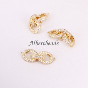 May include: Three gold-tone chain link connectors with clear cubic zirconia stones. The connectors are designed to be used for jewelry making.