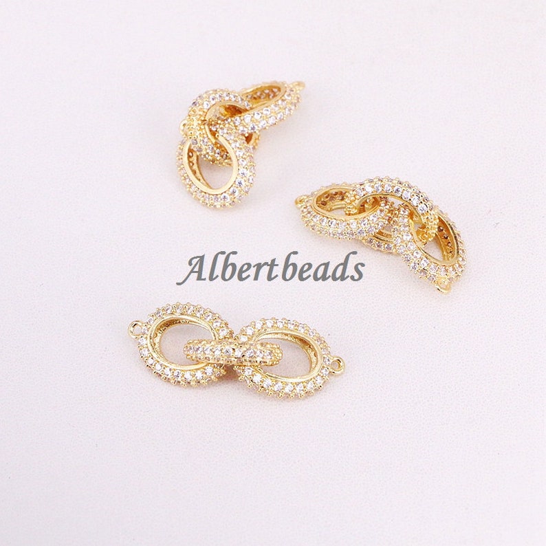 May include: Three gold-tone chain link connectors with clear cubic zirconia stones. The connectors are designed to be used for jewelry making.
