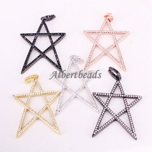 May include: Five silver, gold, black, and rose gold star-shaped pendants with clear crystal accents. Each pendant features a five-pointed star design with a smaller star inside.