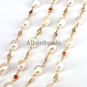 May include: A gold chain necklace with white pearls and colorful gemstones. The necklace is layered and features a repeating pattern of pearls and gemstones.