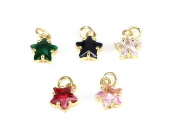 May include: Five gold star charms with different colored gemstones. The charms are green, black, clear, red, and pink.