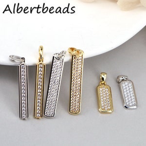 May include: Five silver and gold bar pendants with clear cubic zirconia stones. The pendants are all the same shape and size, but have different finishes. The pendants are perfect for adding a touch of sparkle to any jewelry project.