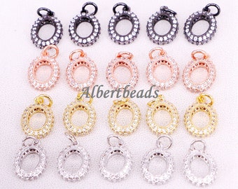 May include: Twenty oval-shaped pendant charms with a clear crystal-like stone encrusted around the perimeter. The charms are available in four different metal finishes: silver, gold, rose gold, and black.