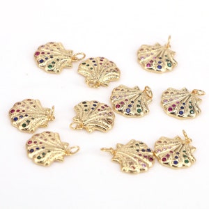 May include: Ten gold-tone shell charms with colourful rhinestones. Each charm has a loop for attaching to a necklace or bracelet.