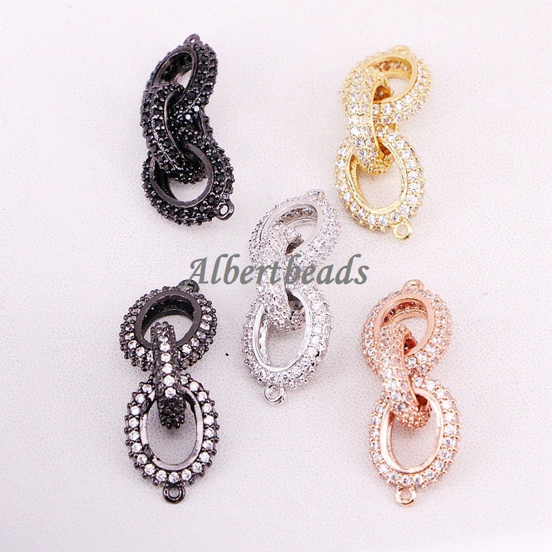 May include: Five different colored metal chain link connectors with clear cubic zirconia stones. The connectors are in black, silver, gold, rose gold, and gunmetal.