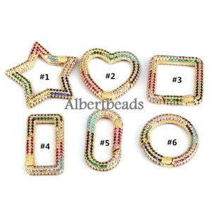 Könnte beinhalten: Sechs goldfarbene Metallverschlüsse mit bunten Kristall-Akzenten. Die Verschlüsse sind in Form eines Sterns, Herzens, Quadrats, Rechtecks, Ovals und Kreises. Jeder Verschluss ist von 1 bis 6 nummeriert.