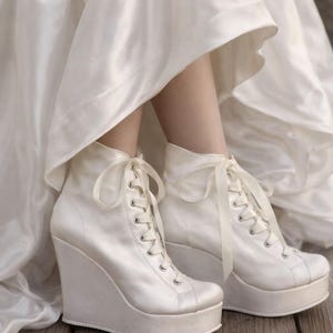 May include: A set of three ceramic mugs with a speckled, matte finish. The mugs are in shades of cream, light gray, and dark gray. Each mug has a simple, minimalist design and a rounded handle.