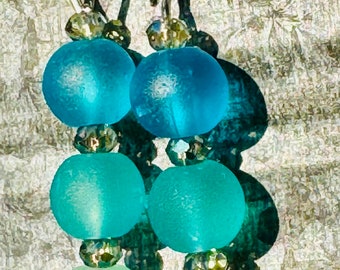 May include: A pair of dangle earrings with turquoise and light green glass beads and silver accents.