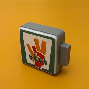 May include: A gray and white sign with a green border. The sign features a red hand with four raised fingers and the text "Five Guys".
