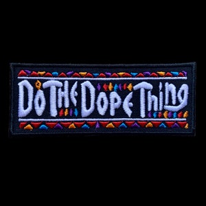 Könnte beinhalten: Rechteckiger, schwarzer Aufnäher mit dem weißen Schriftzug "Do The Dope Thing". Der Aufnäher hat farbenfrohe geometrische Muster in Rot, Orange, Lila und Blau an den oberen und unteren Rändern. Ein dekoratives Element.