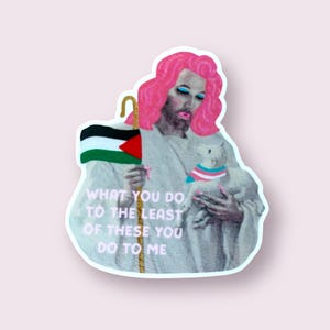 May include: A sticker depicting a figure with pink hair and makeup, holding a Palestinian flag and a lamb wearing a transgender flag collar. The text reads "WHAT YOU DO TO THE LEAST OF THESE YOU DO TO ME."