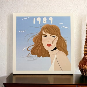 May include: A digital illustration of a woman with long brown hair, wearing a white sleeveless top. The background is a light blue sky with white birds flying. The year 1989 is written in white at the top of the image.