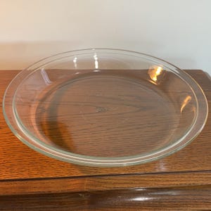 Può includere: Una tortiera in vetro trasparente con un bordo rialzato. La tortiera è di Pyrex.