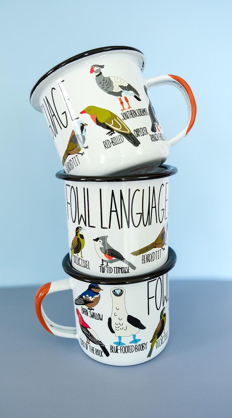 May include: Three white enamel mugs stacked, each featuring bird illustrations and the words "FOWL LANGUAGE." The top mug has an orange handle. Birds include a Southern Screamer and a Red-Billed Woodpecker. The middle mug features a Tufted Titmouse.