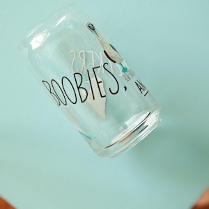 May include: A clear glass cup with a blue-footed booby bird illustration and the text "Boobies, Blue-Footed" printed on the side.