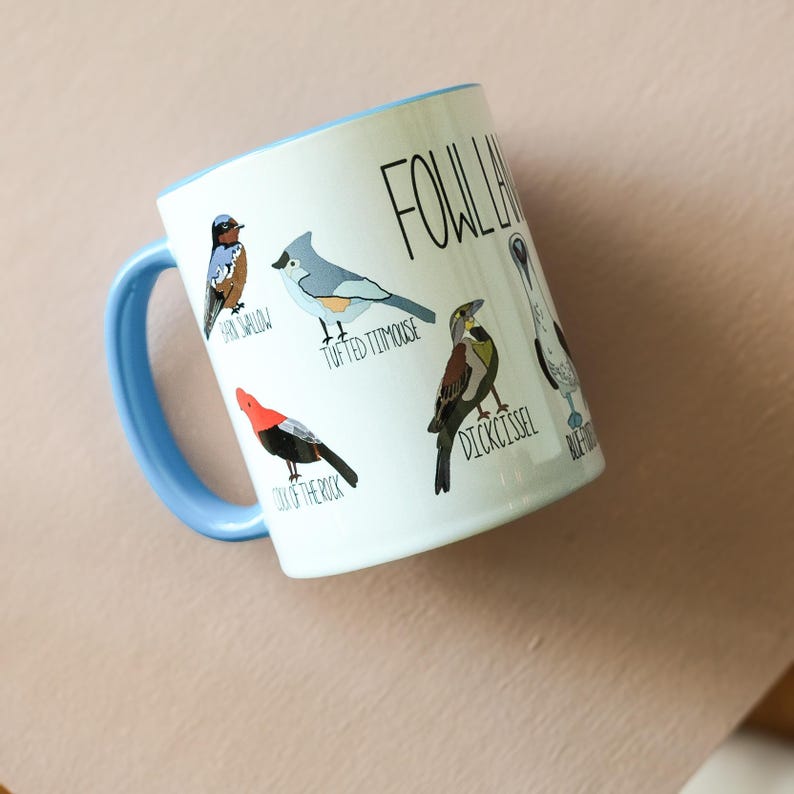 Fowl language mug with 9 cheeky named birds. Mug is ice blue with multi color birds and black writing. Rim and handle are blue