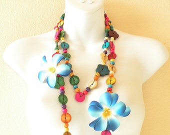 Peut inclure: Un collier de perles en bois coloré avec des accents de fleurs bleues. Le collier est composé de perles rondes en bois de différentes couleurs, notamment rouge, orange, jaune, vert, bleu et violet. Le collier est enfilé sur une ficelle et comporte deux accents de fleurs bleues.
