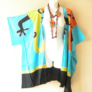 May include: A blue, yellow, orange, and black patterned kimono with a colorful wooden bead necklace. The kimono has a frog design on the front.