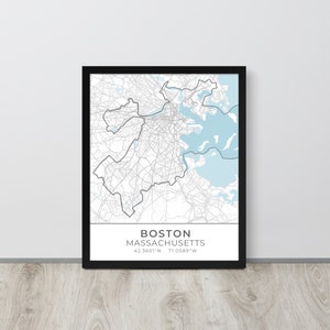 May include: Framed map print of Boston, Massachusetts, with a black frame. The map features a detailed street layout in gray, with light blue water areas. The city name and coordinates are displayed at the bottom.