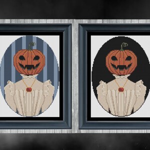 May include: Two framed cross-stitch portraits of a person with a pumpkin head wearing a white dress and a red jewel necklace. The background of the left portrait is blue and white stripes, and the background of the right portrait is black.