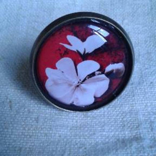 bague fleurs blanches sur fond rouge