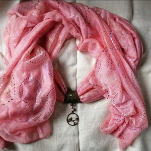 printed pink scarf and its bird jewel