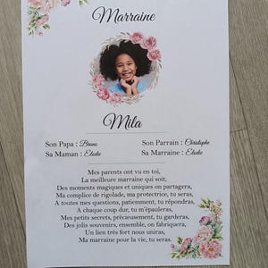 May include: A white paper certificate titled CERTIFICAT DE Marraine Modèle 1, featuring a circular photo of a child surrounded by pink floral illustrations. It includes the name Mila, names of parents and godparents, and a French poem printed in black.