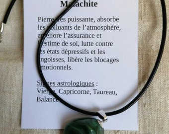 May include: A green malachite stone pendant on a black cord necklace. The pendant is a natural stone with a swirling pattern. The card reads "Malachite" and describes the stone's properties and astrological signs.