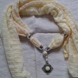Yellow scarf and its print and flower jewelry