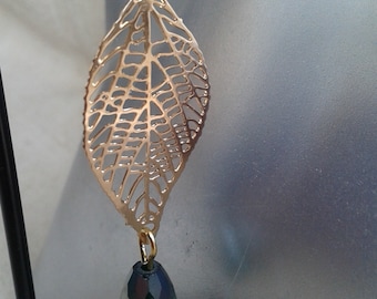 May include: Gold leaf-shaped dangle earrings with a dark green faceted teardrop pendant.