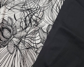 May include: A fabric featuring a high-contrast design with a solid black section on the right and a white section on the left. The white area displays a detailed black line art pattern of stylized lotus flowers and flowing, curved abstract lines.