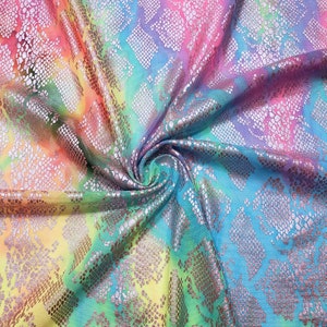 May include: A rainbow ombre fabric with a silver snakeskin pattern. The fabric is folded and twisted, showing the different colors and patterns.