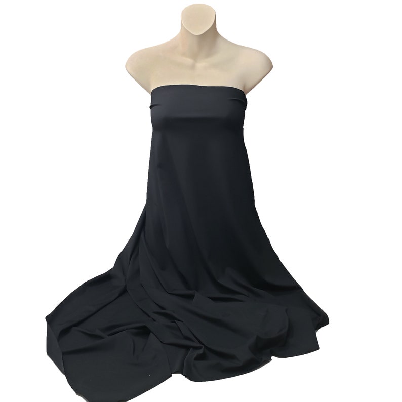 May include: A black strapless dress displayed on a mannequin. The fabric drapes down, creating soft folds and a flowing effect. The dress is made of a smooth, solid-colored material.