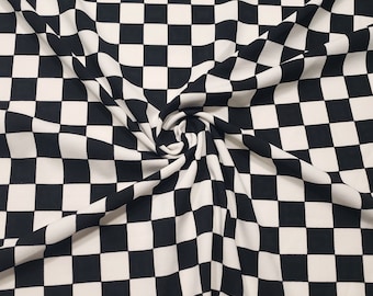 May include: Black and white checkered fabric with a large, swirling fold in the center.