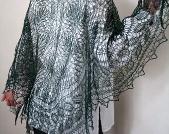 May include: A dark green lace shawl with a delicate pattern. The shawl is draped over a person's shoulders and is worn with a white shirt and black trousers.