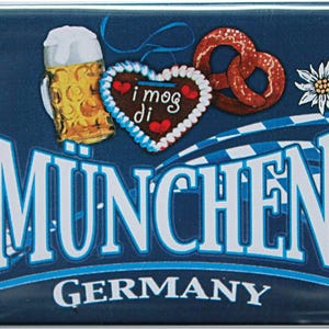 Könnte beinhalten: Ein rechteckiger Magnet mit dunkelblauem Hintergrund, der einen Bierkrug, einen herzförmigen Keks und eine Brezel zeigt. Das Wort "MÜNCHEN" ist in Weiß dargestellt, darunter "GERMANY". Das Design enthält bayerische Flaggenelemente.