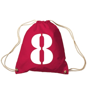 Könnte beinhalten: Roter Turnbeutel mit einer großen weißen Zahl Acht auf der Vorderseite. Die Tasche hat beige Kordelzüge und ein schlichtes Design. Die Tasche ist aus leichtem Material gefertigt. Die Zahl Acht ist fett gedruckt.
