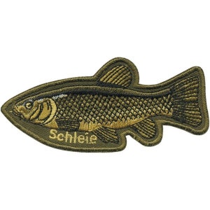 Könnte beinhalten: Ein grüner gestickter Aufnäher mit einem Fisch und dem Wort "Schleie" darunter. Der Fisch ist mit goldfarbenem Garn detailliert.